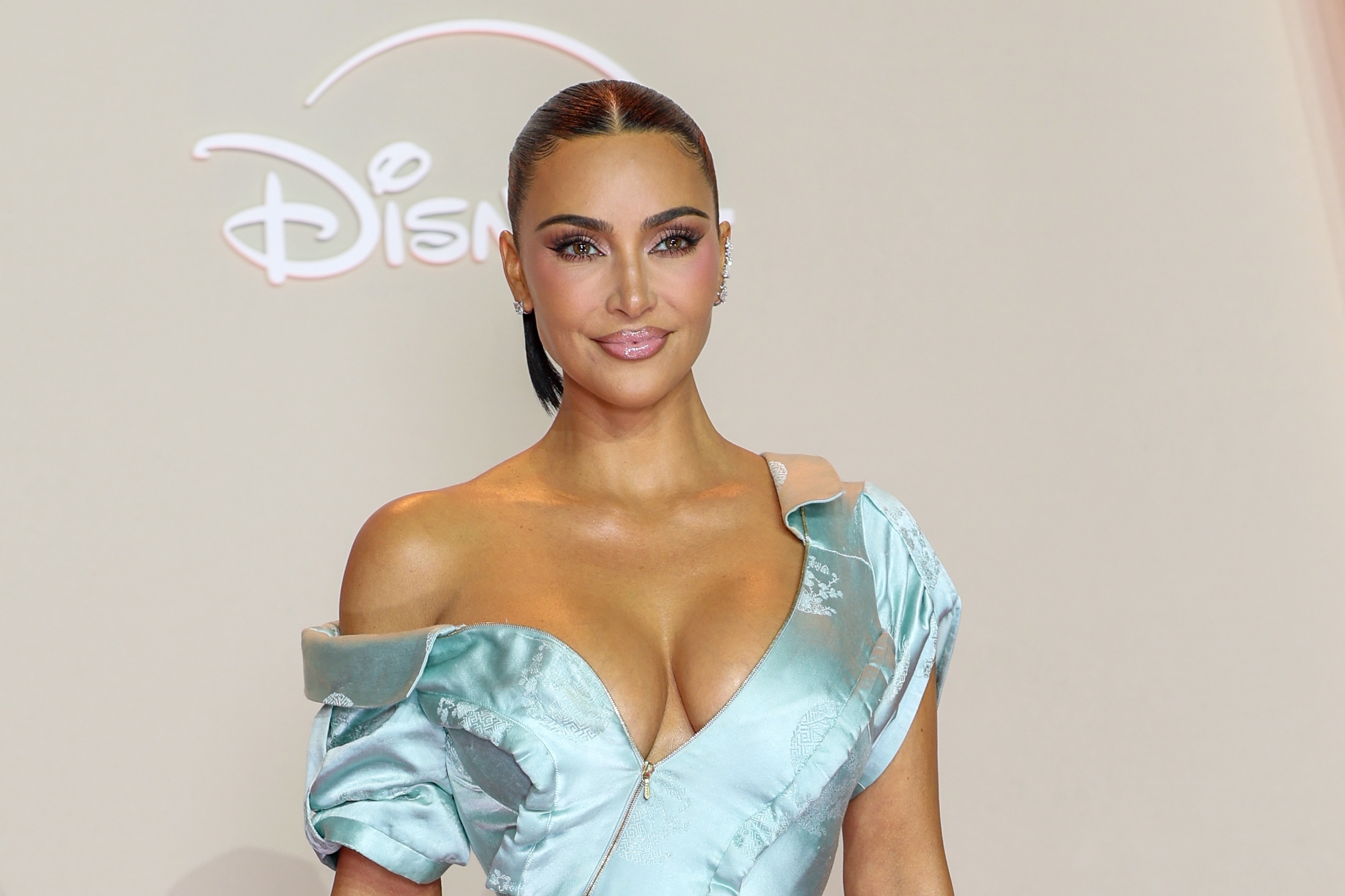 Person successful  off-shoulder, satin gown lasting  astatine  an lawsuit   backdrop