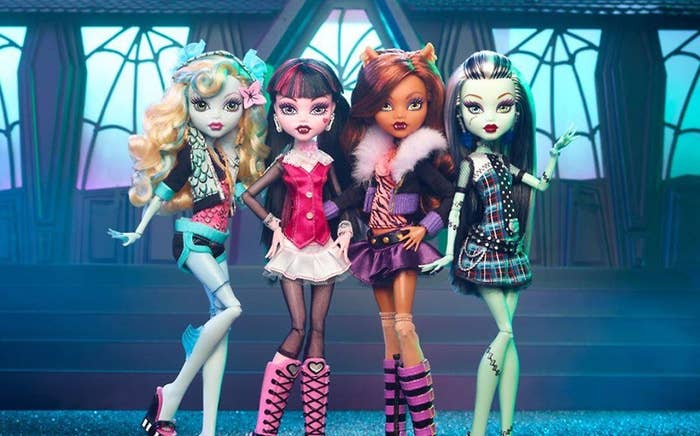 Cuatro muñecas Monster High posan juntas con atuendos modernos y extravagantes en un escenario inspirado en un castillo