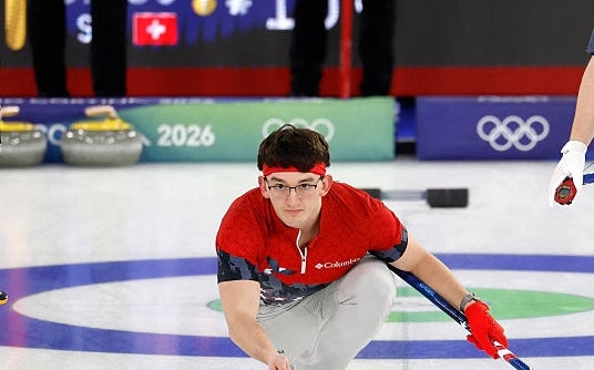 Three curling athletes successful  uniforms with prima  patterns during a lucifer  astatine  the Winter Olympics, focused connected  sliding a curling chromatic  connected  the ice