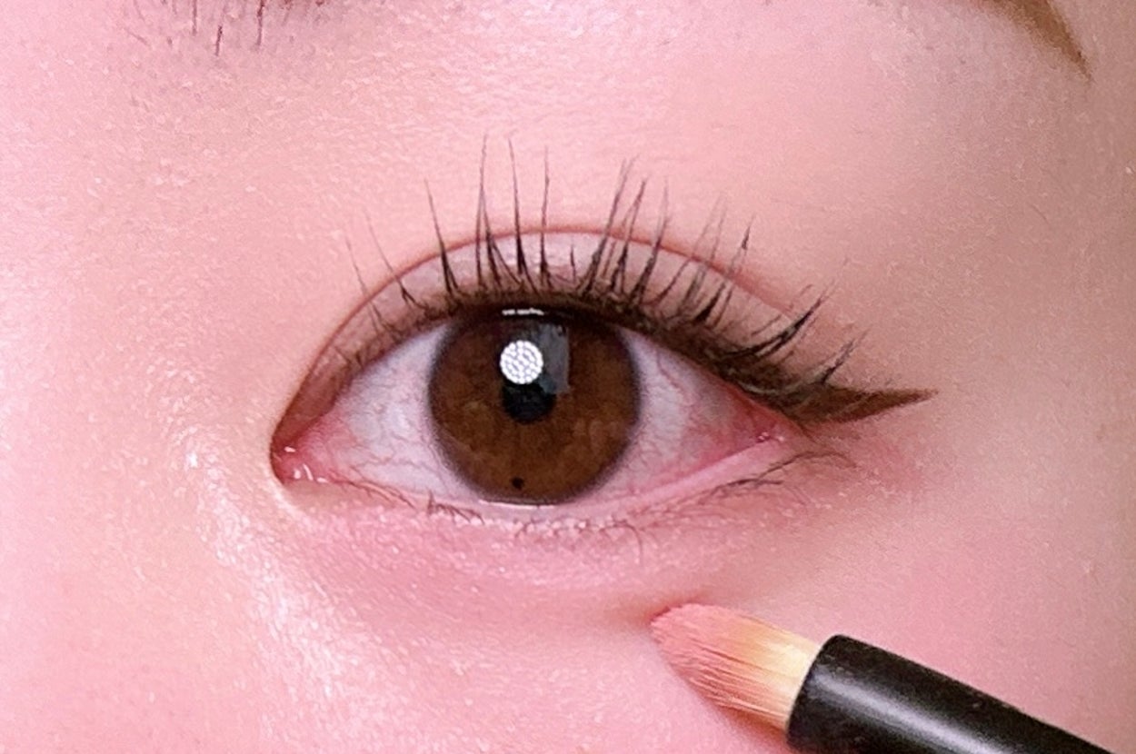 目のメイクアップ写真。アイライナーが引かれ、細いブラシでさらにメイクが施されている。