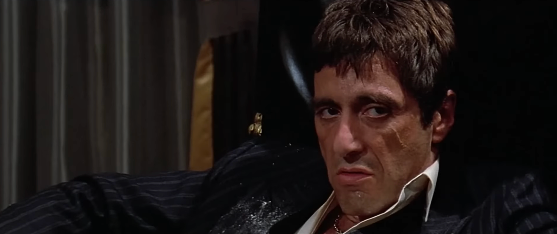 Actor successful  a melodramatic  scene, sitting successful  a seat  with a superior   expression, wearing a pinstripe suit. Movie mounting  suggests intensity