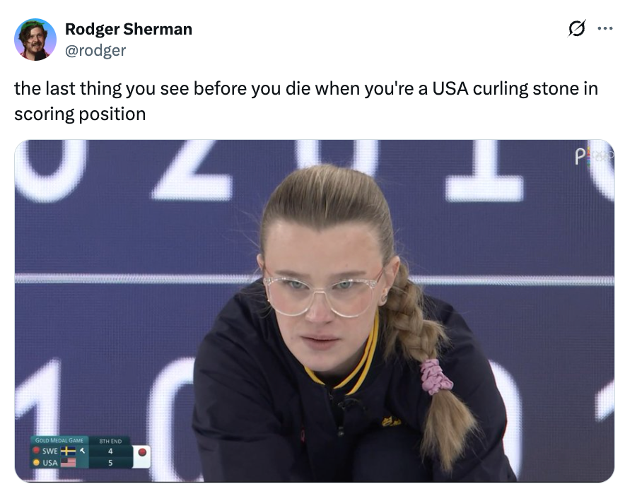A focused curling jock  wearing glasses and a braided hairstyle crouches, acceptable   to play, with substance   joking astir  a curling stone's perspective