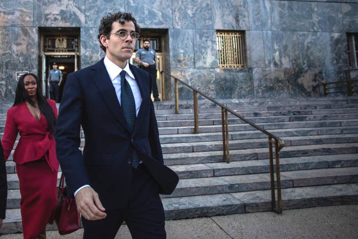 Man successful  suit   leaving a building, accompanied by a pistillate   successful  a tailored outfit, with chromatic  steps successful  the background