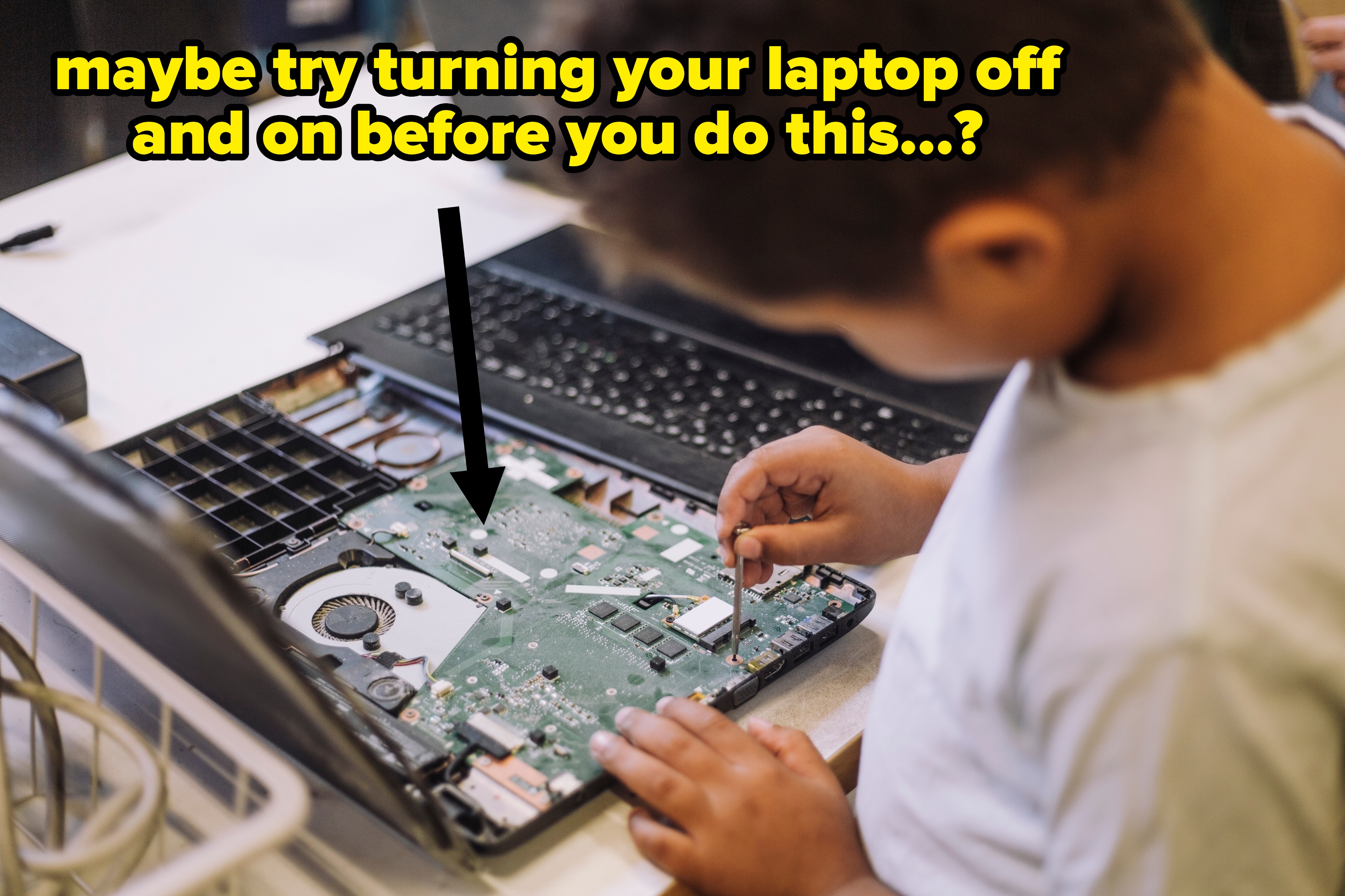 Barn fokuserte på å reparere en bærbar datamaskin, undersøke og håndtere interne komponenter på et bord