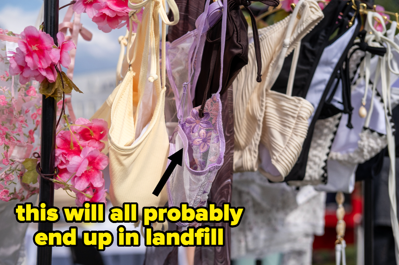 Klær, inkludert topper og kjoler, henger på et stativ utendørs med rosa blomster. Teksten lyder: 