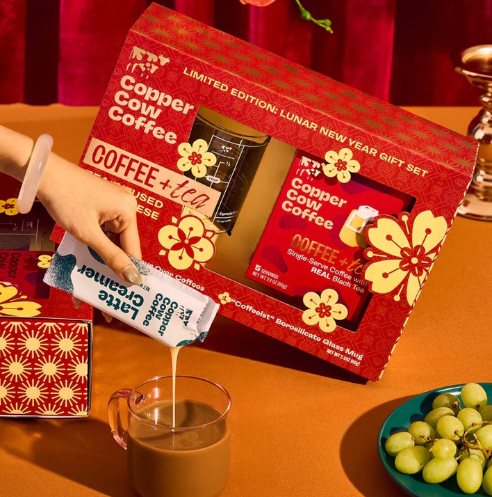 Limited variation  Copper Cow Coffee and beverage  acquisition  acceptable   displayed, with creamer being poured into a solid  mug. Grapes and a decorative array  mounting  visible