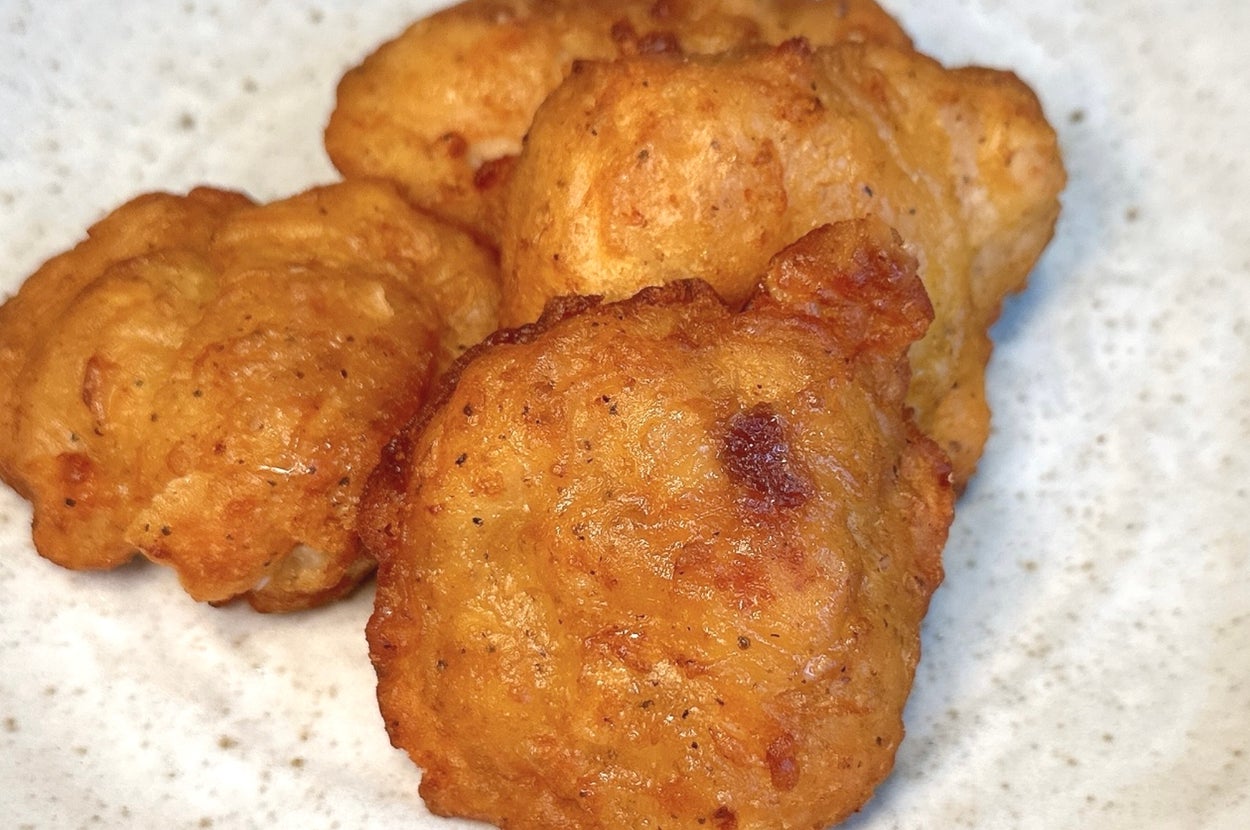 白い皿に盛られた数個の揚げ物のクロースアップ。