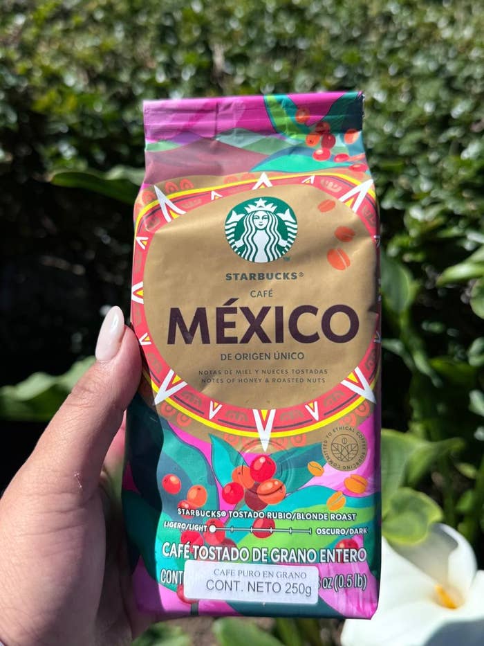 Paquete de café Starbucks México, tostado rubio, sostenido por una mano frente a un fondo de plantas