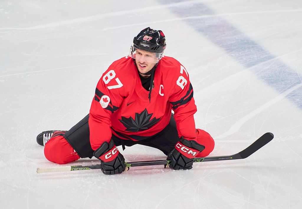 Hockeyspiller i aksjon på isen, iført sportsutstyr med et fremtredende lønneblad