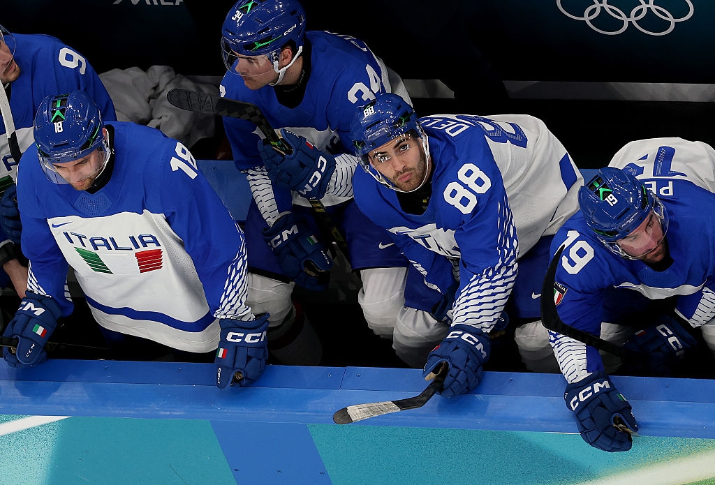 Hockeyspillere iført blå og hvite trøyer med 