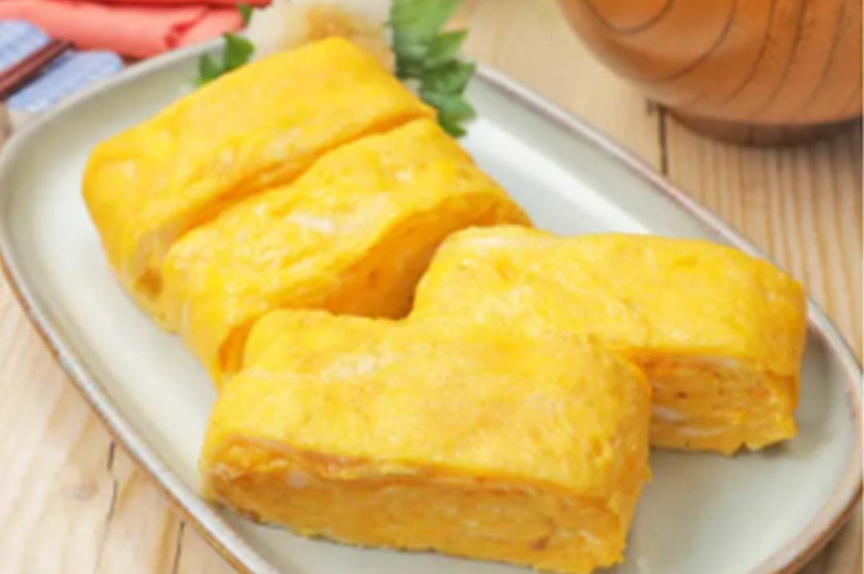 卵焼きが皿に盛られ、横に味噌汁も添えられている和風朝食の一部。