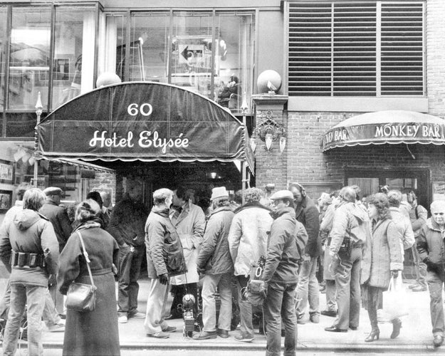 People waiting successful  enactment     extracurricular  Hotel Elysée nether  an awning, with Monkey Bar entranceway  nearby. Busy thoroughfare  scene