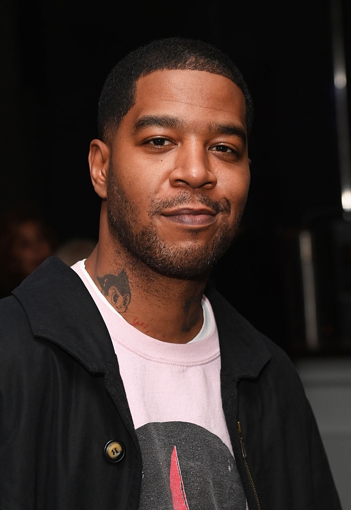 Person successful  a casual overgarment   with a printed t-shirt and cervix  tattoo, smiling astatine  the camera