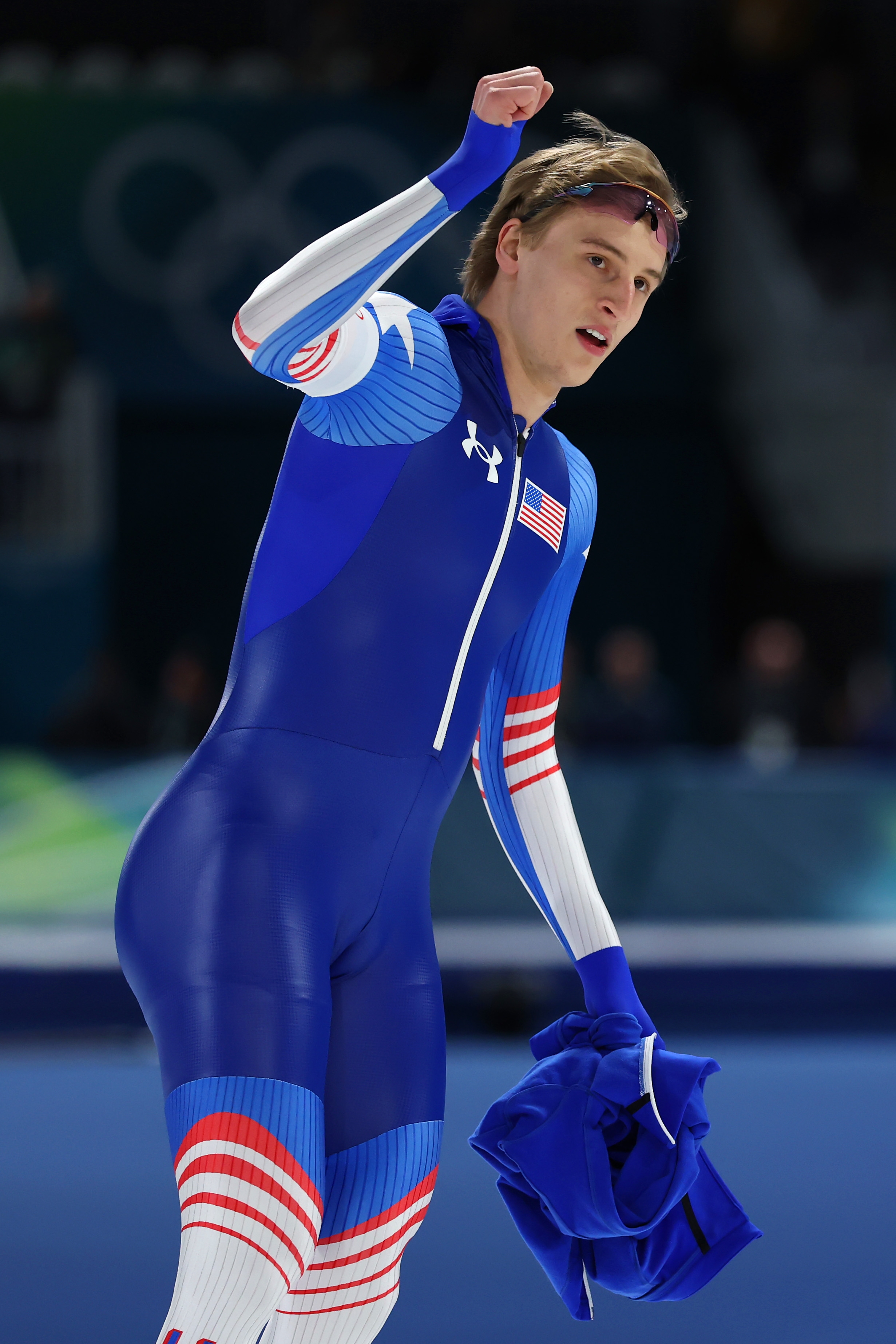 Athlete successful a sleek bodysuit celebrates astatine an Olympic crystal rink, raising a fist with determination