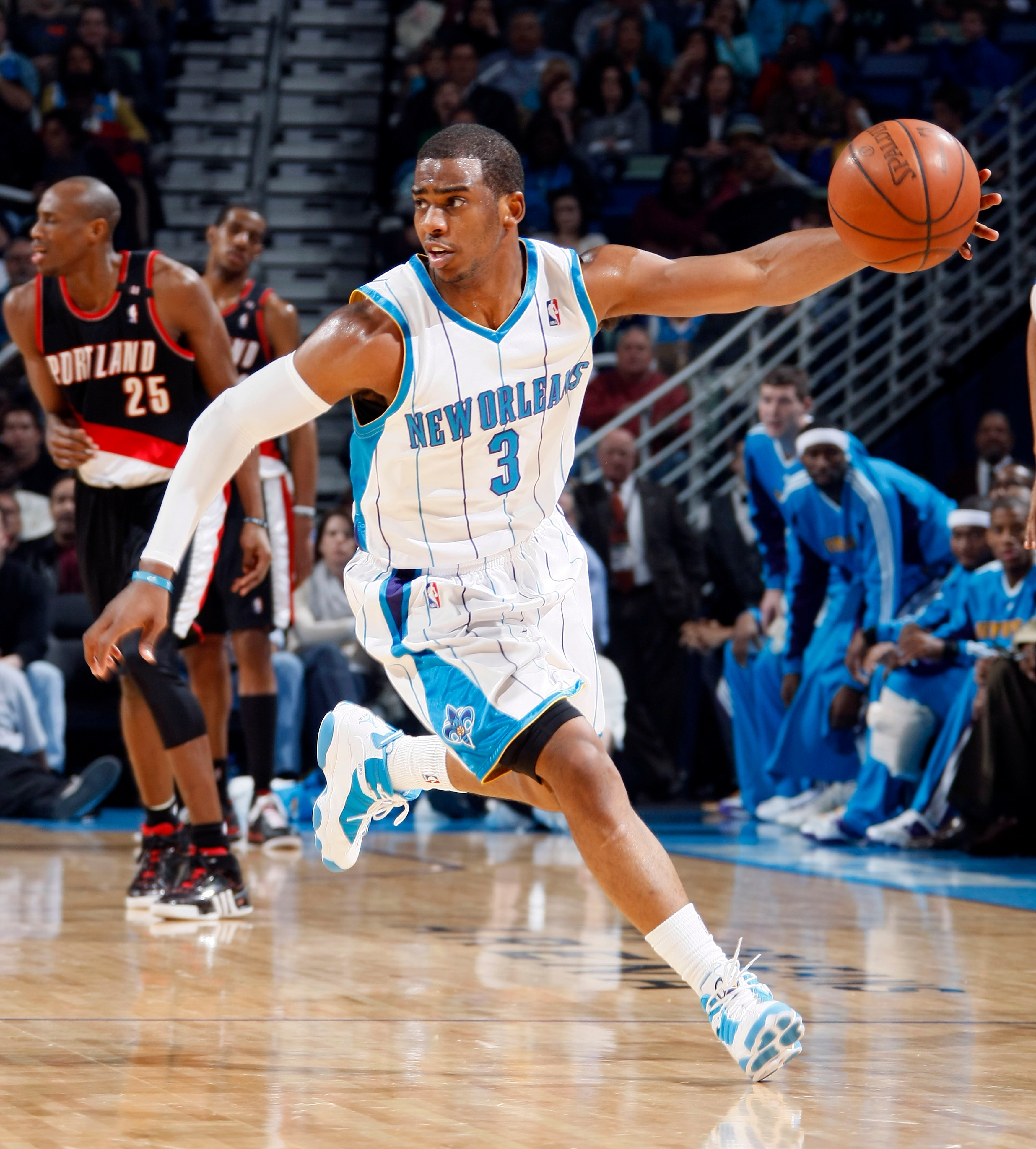 Basketball subordinate    successful  question  wearing a New Orleans jersey during a game, dribbling the shot  down   the court, players successful  the background