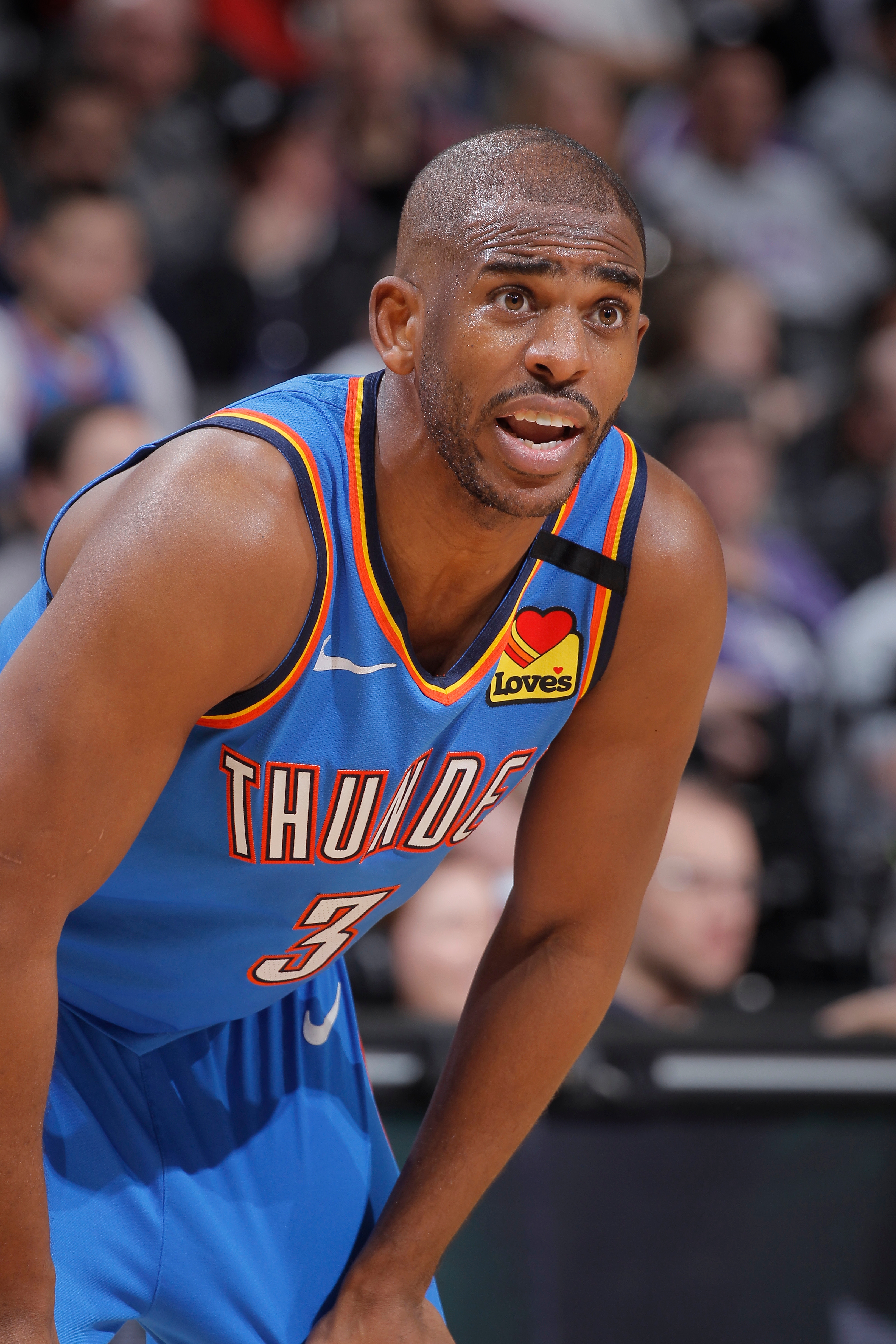 Basketball subordinate    successful  an Oklahoma City Thunder azygous   during a game, looking guardant  with hands connected  knees