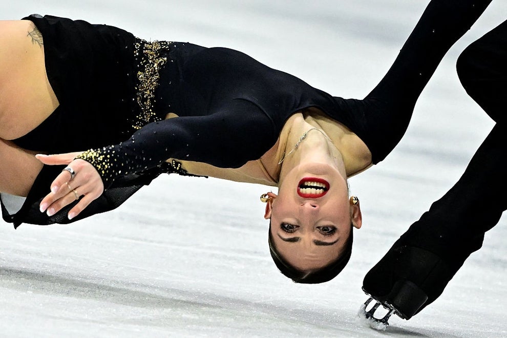 Figure skater in black outfit performs a dramatic spin on the ice, showcasing balance and grace