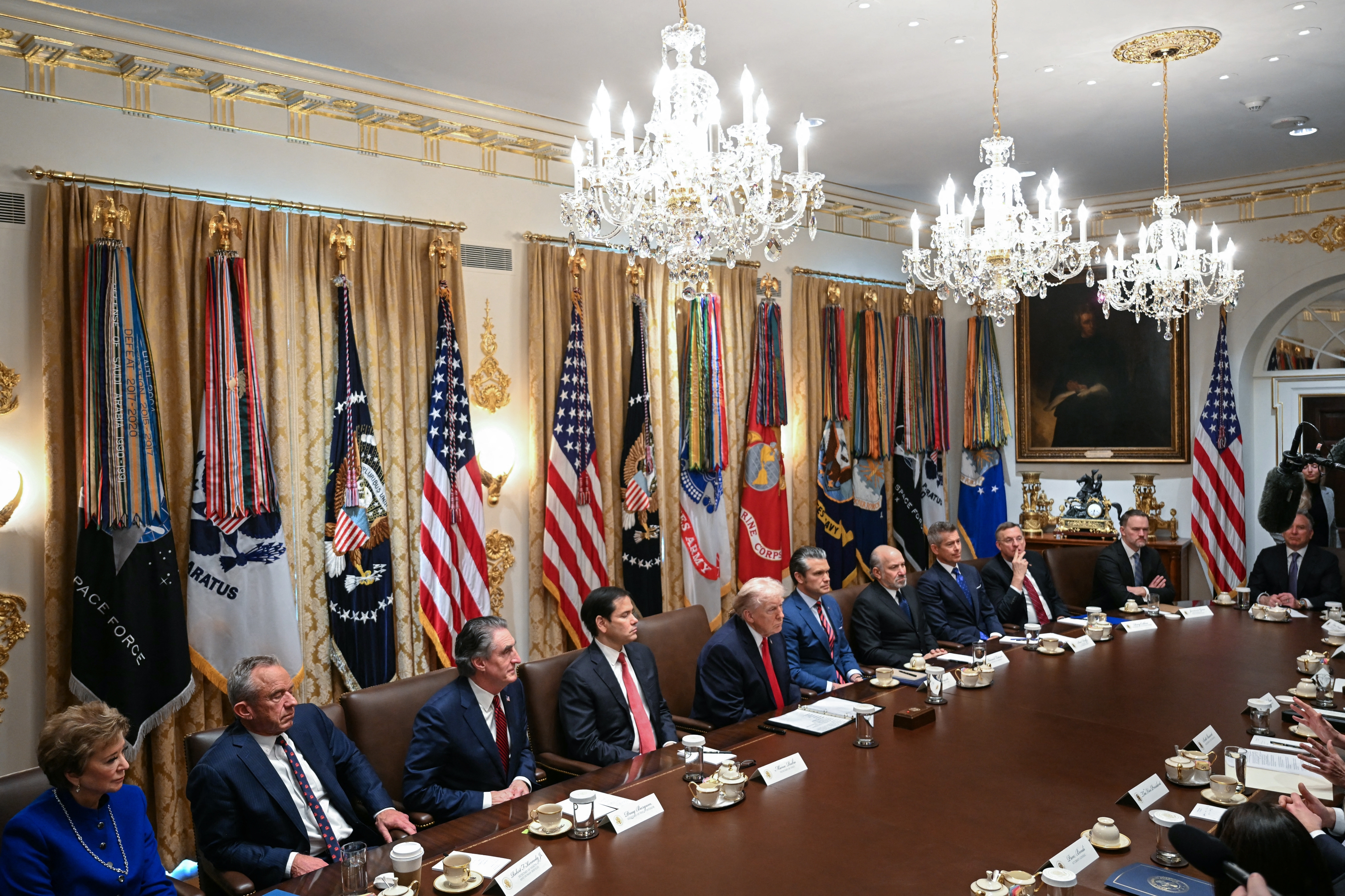 Meeting successful  a ceremonial  country   with chandeliers, respective  officials beryllium   astir   a ample  array  adorned with U.S. flags and subject   banners