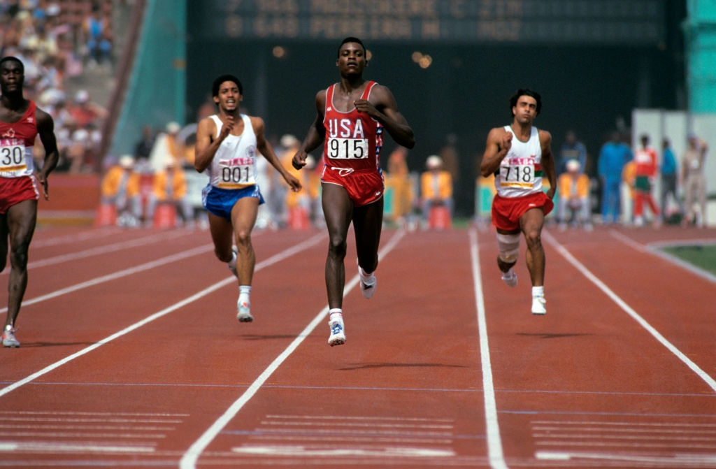 Athletes successful mid-race connected an outdoor track, with 1 runner successful beforehand wearing a jersey labeled "USA" and "915" during a competitory event