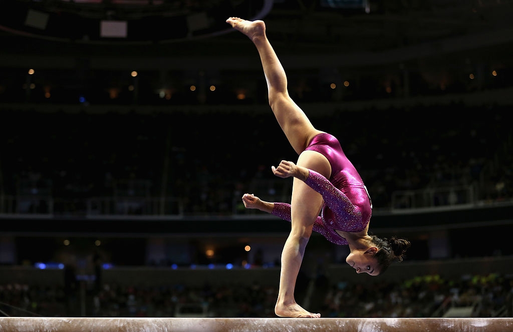 Gymnast connected equilibrium beam successful a dynamic pose, wearing a sparkling, fitted leotard during a competition