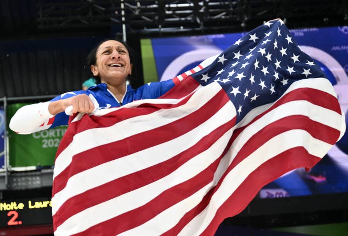 Person joyfully holding a ample  American flag, apt  celebrating an diversion  achievement, wearing a sports outfit