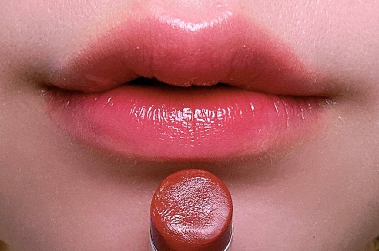 唇に口紅を塗っているクローズアップの写真。