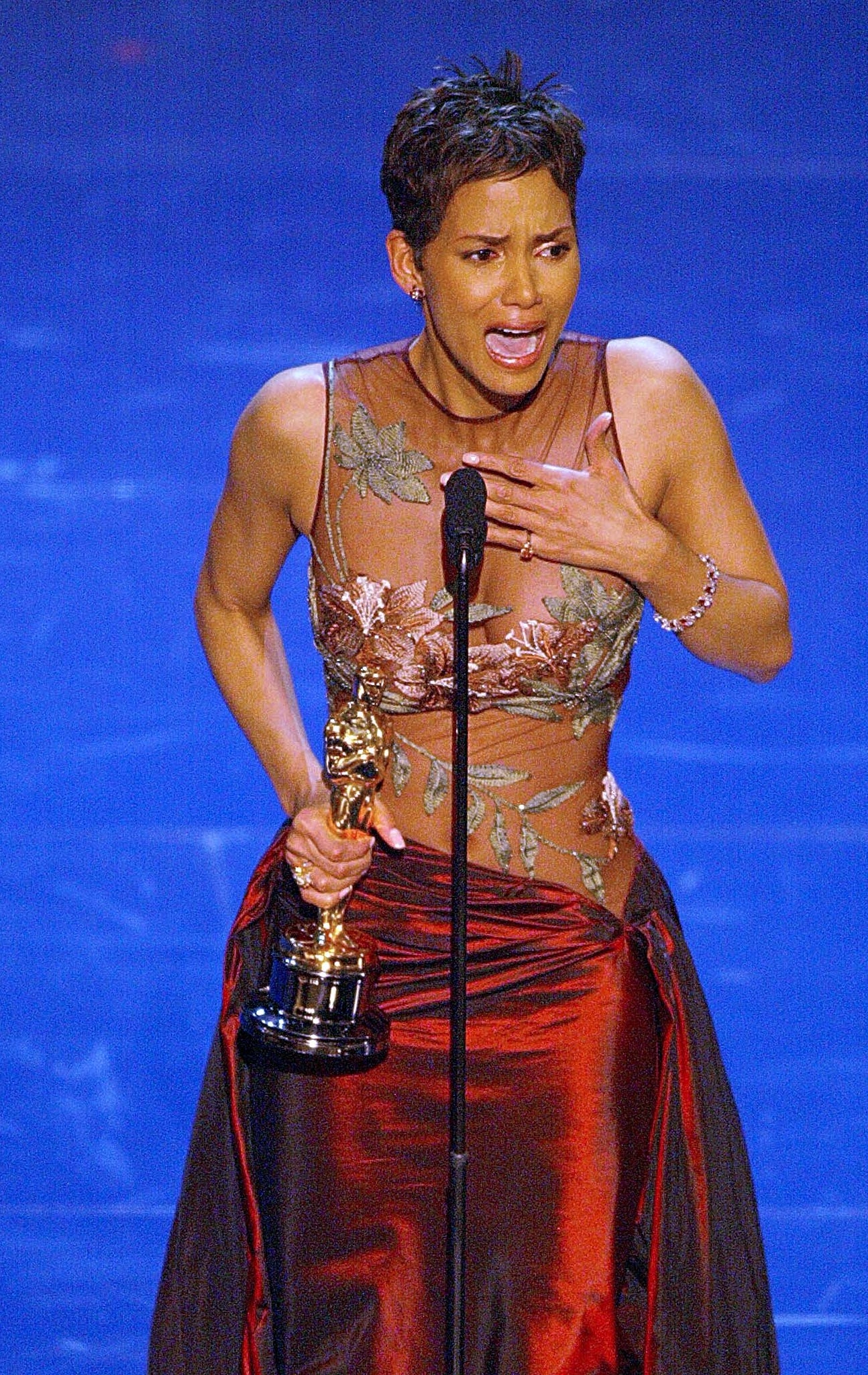 Halle Berry holding an award, speaking emotionally connected  stage