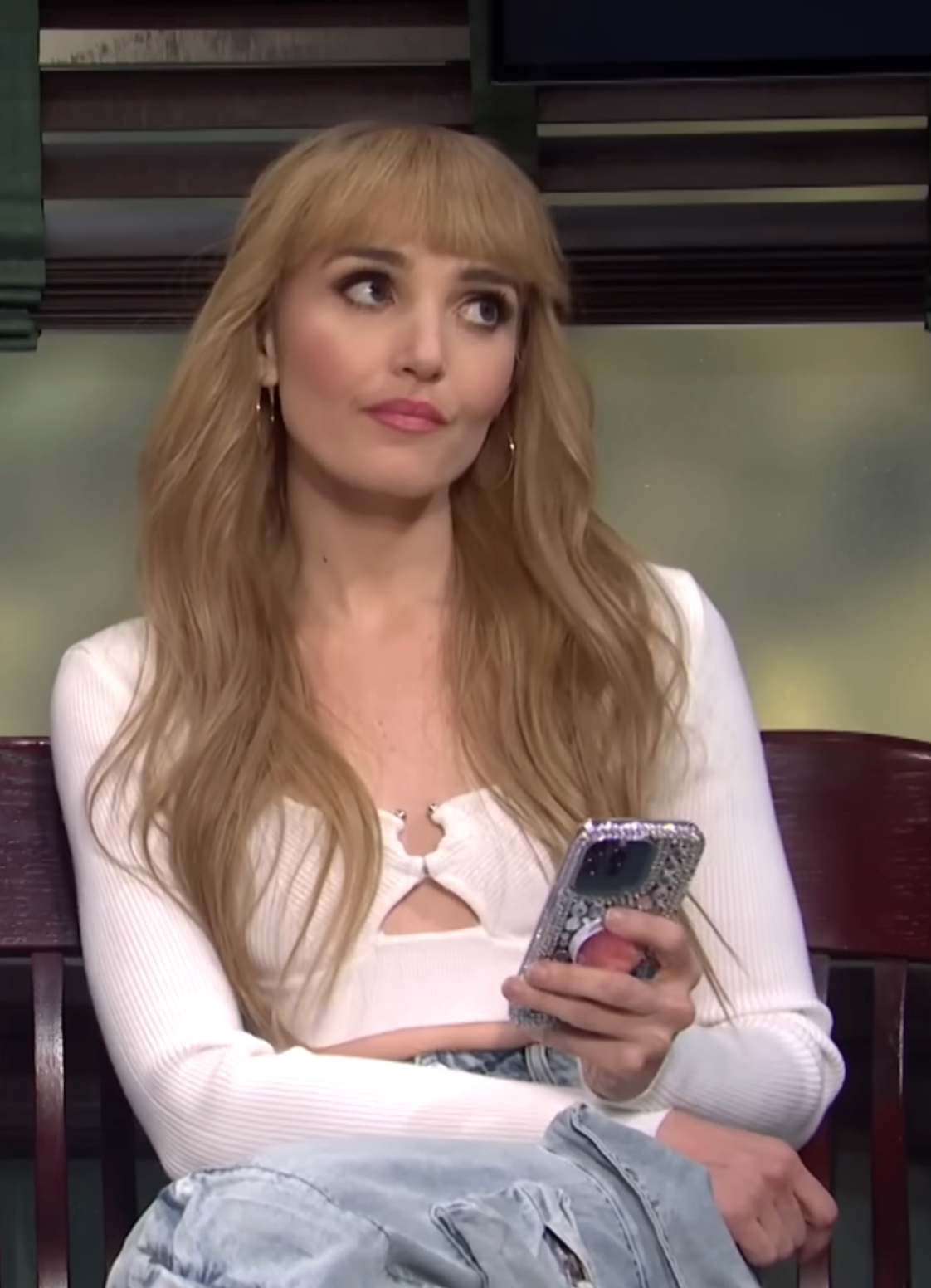 Chloe Fineman arsenic  a stereotypical Gen Z girl, wearing a trendy apical  and holding a sparkly iPhone