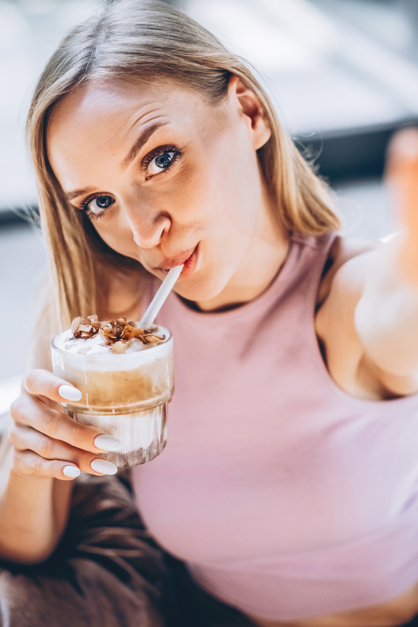 woman taking a selfie with a fancy iced coffee
