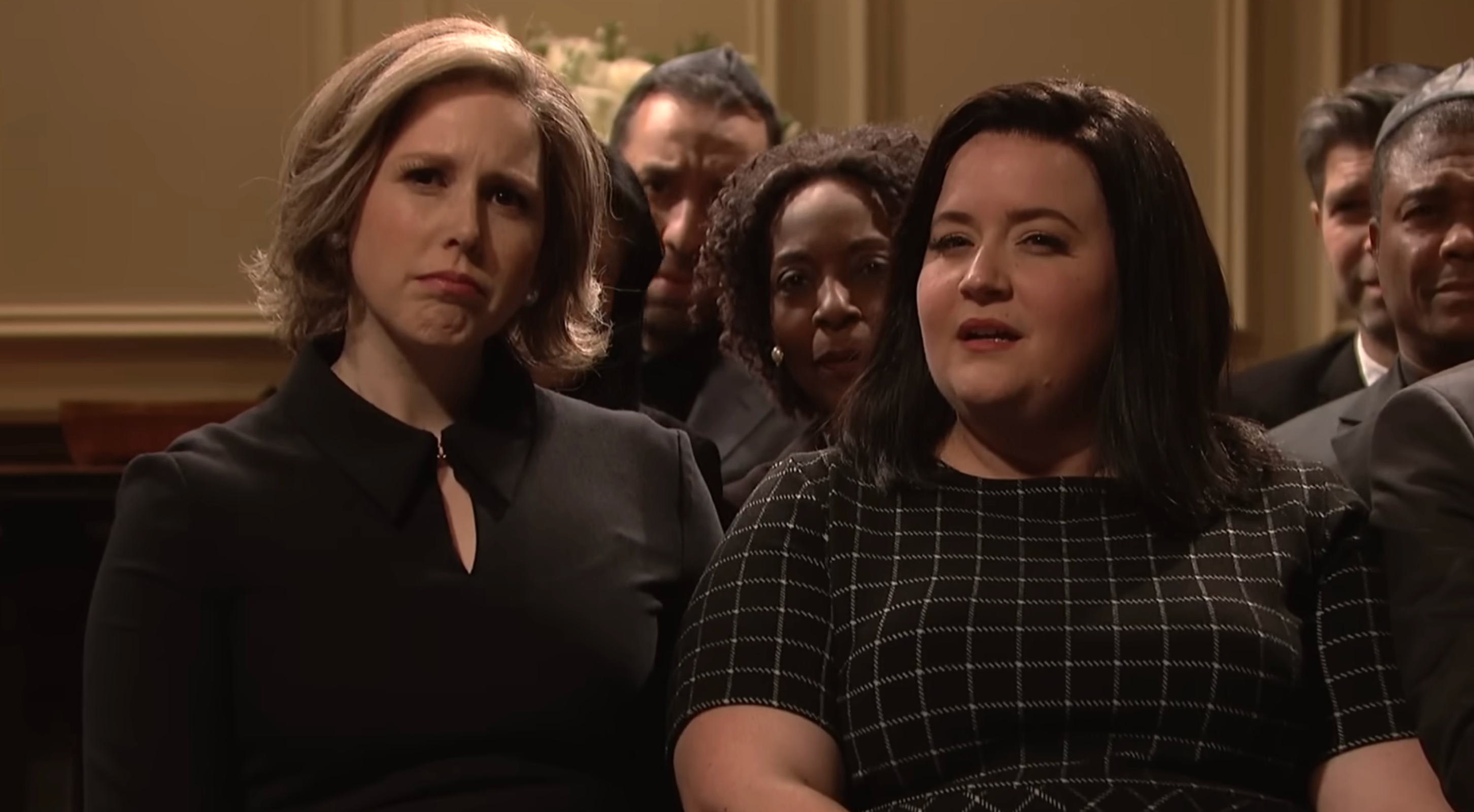 Funeral goers side-eyeing the speaker