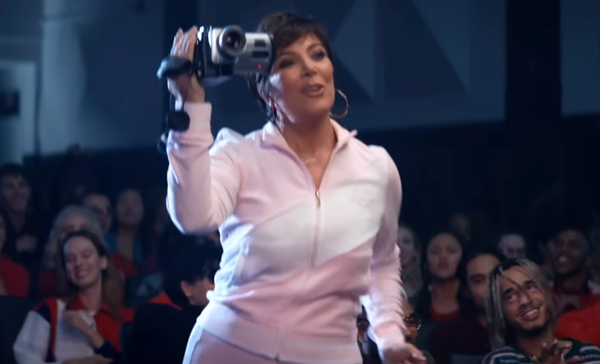 Kris Jenner with a camcorder, lasting  successful  beforehand   of a seated audience