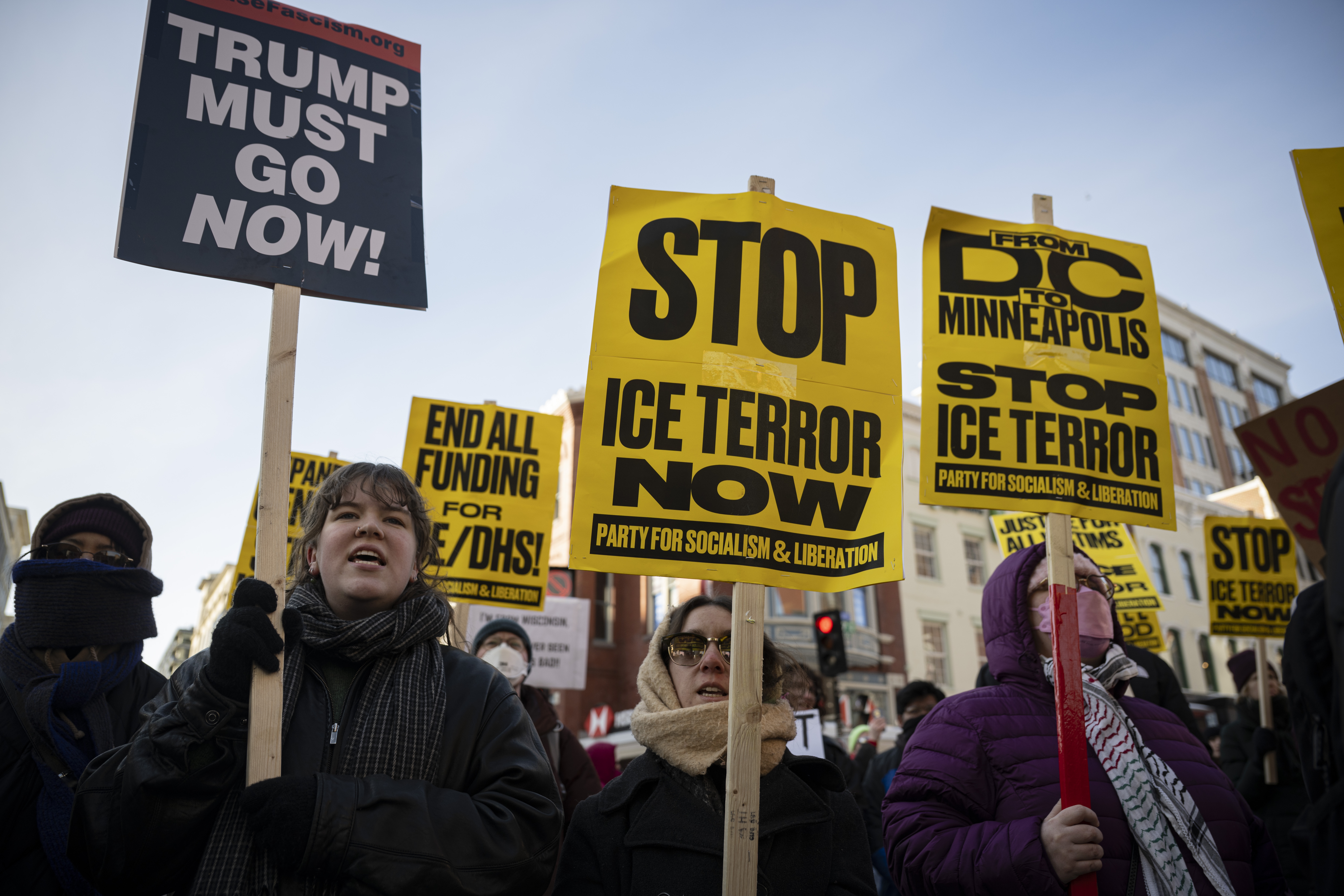 Demonstranter holder skilt med meldinger som 