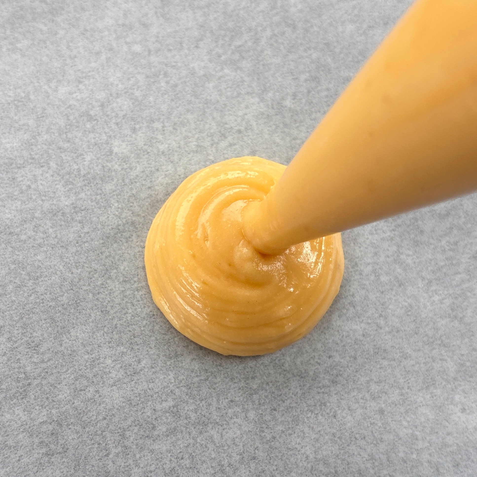 絞り袋からシュー生地が出されている様子。