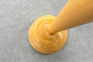 絞り袋からシュー生地が出されている様子。