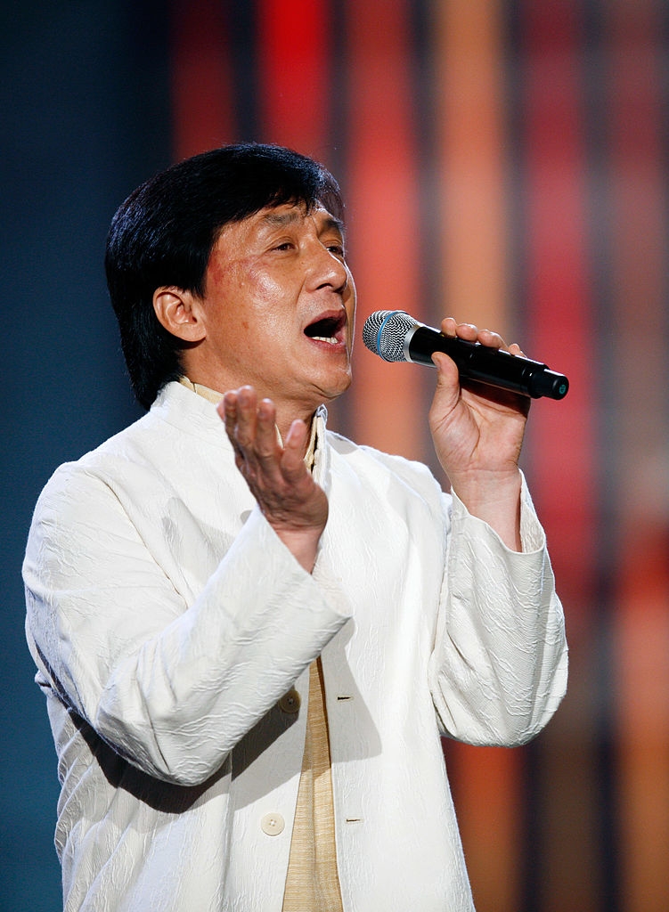 Person successful  a airy  overgarment   singing passionately into a microphone connected  stage