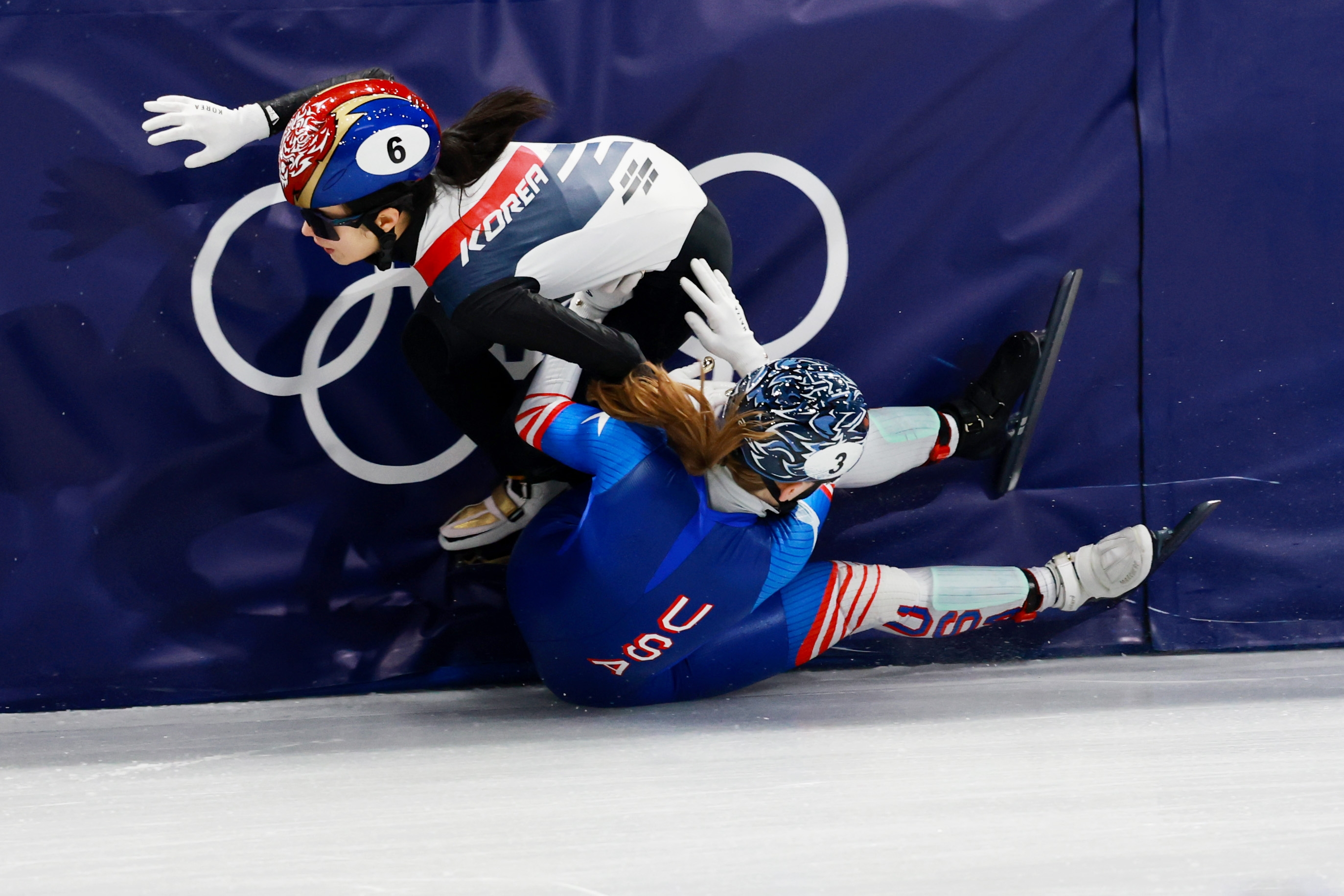 To hurtigløpere krasjet inn i bommen under et OL-løp, begge med hjelm og skøyter