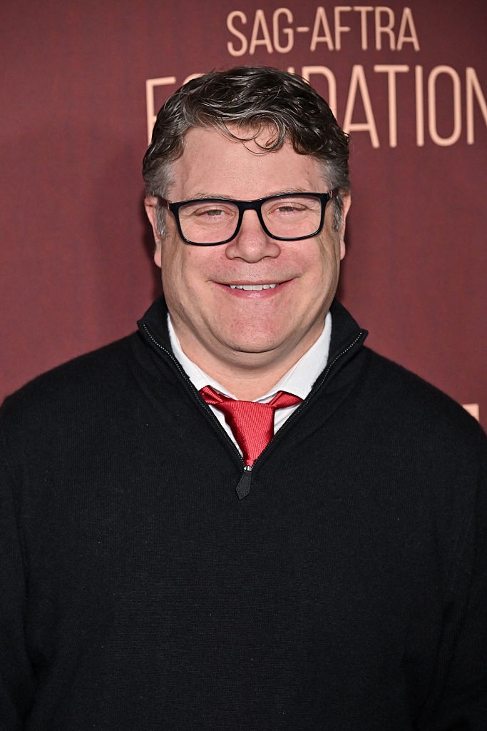 Person successful  glasses wearing a achromatic  zip-up sweater implicit    a achromatic  garment  and reddish  necktie  astatine  a SAG-AFTRA Foundation event