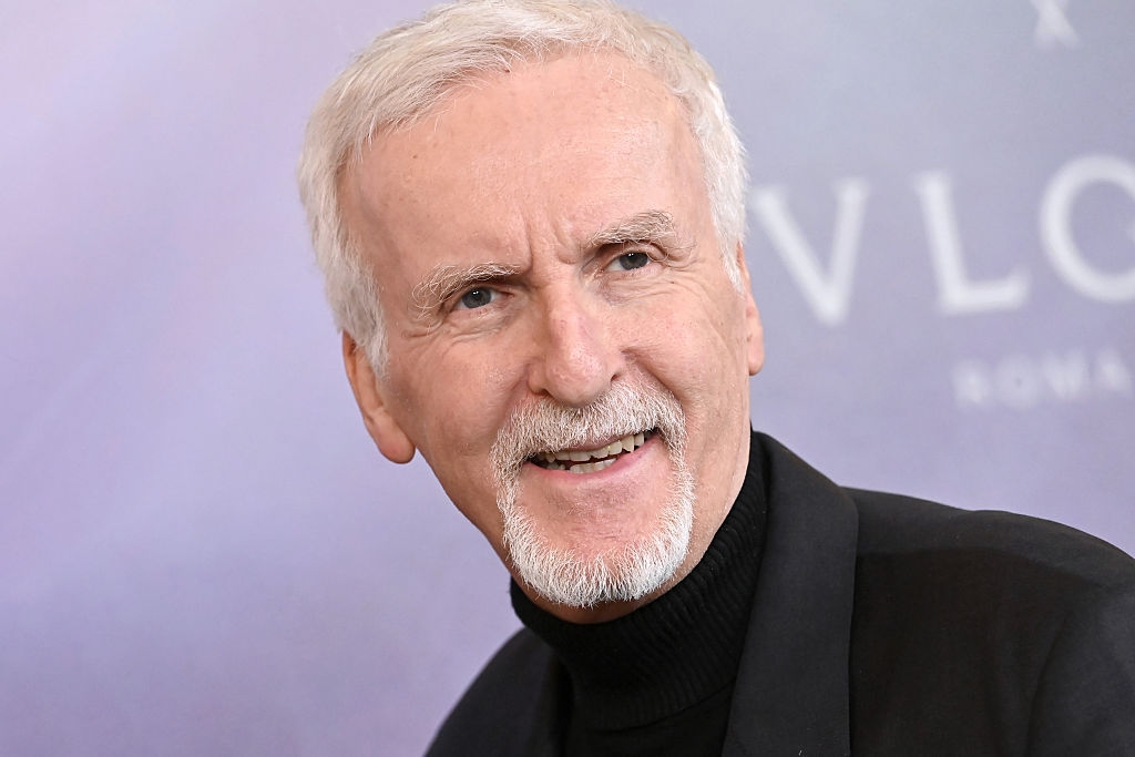 A idiosyncratic   with abbreviated  hairsbreadth  and a goatee, wearing a acheronian  blazer and turtleneck, smiling astatine  an event