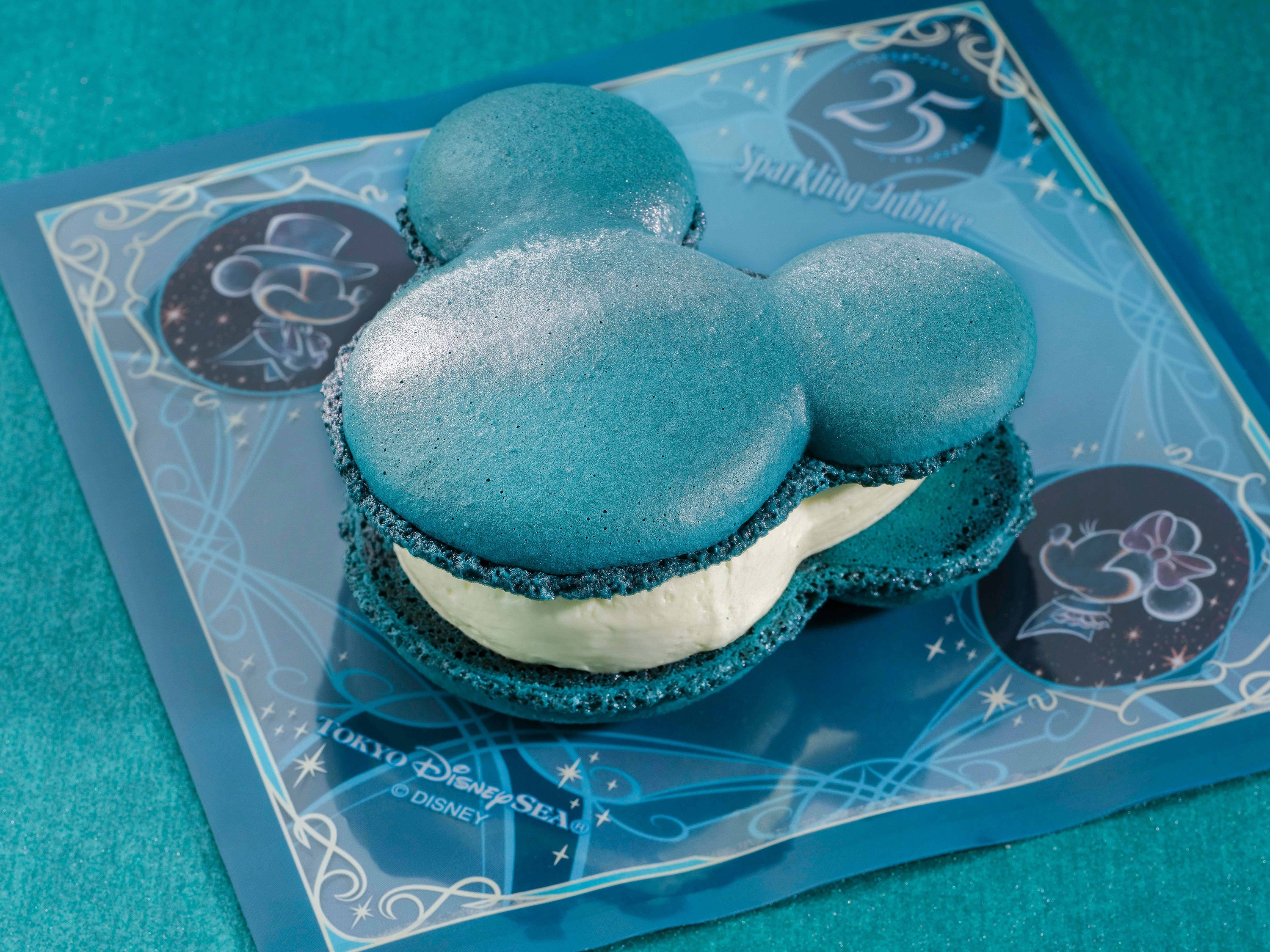 ミッキー型のマカロンアイスクリームサンドイッチが、ディズニーの記念ボード上に置かれています。