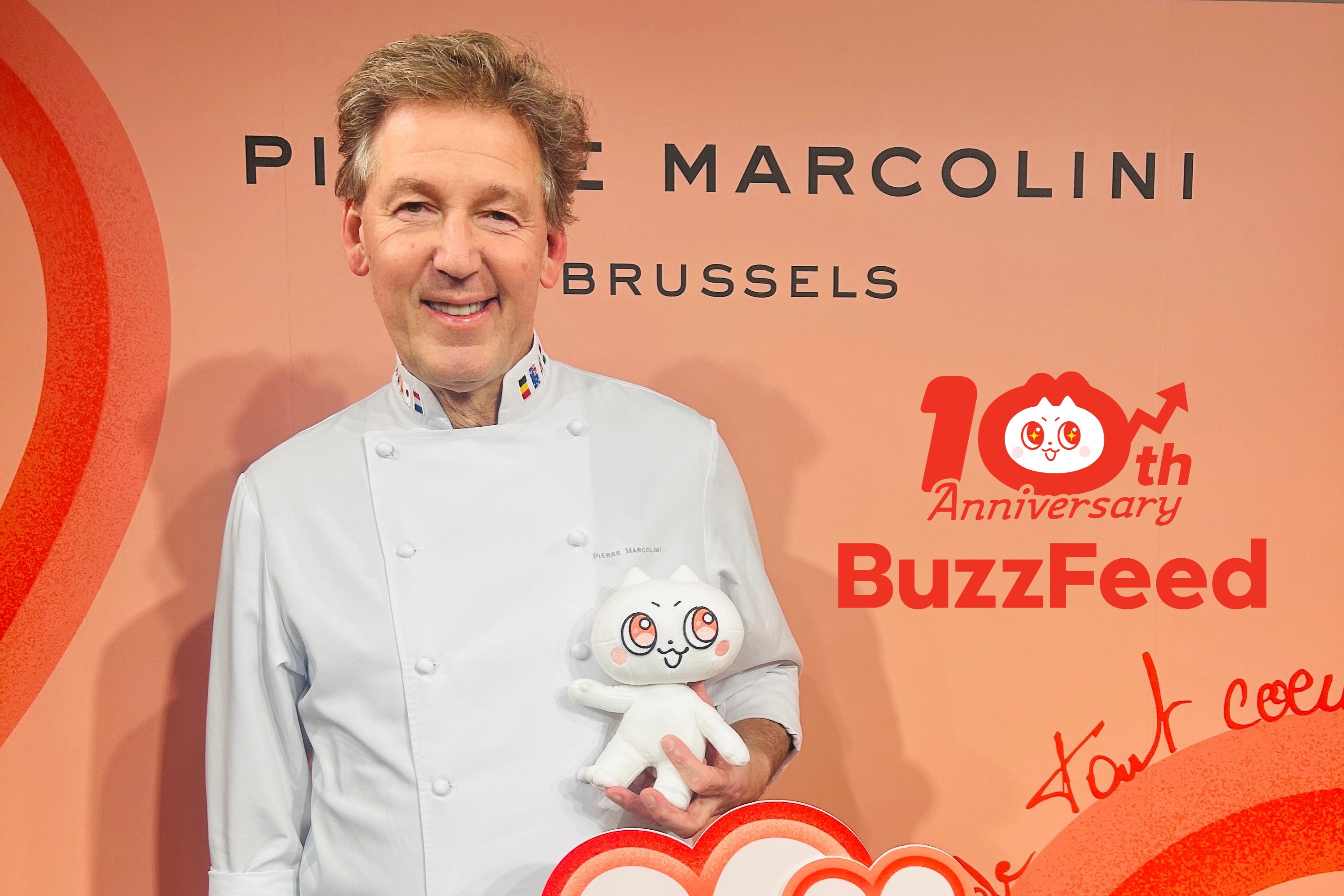 ピエール マルコリーニ氏が片手に「バズりん」のマスコットを抱えている様子の画像