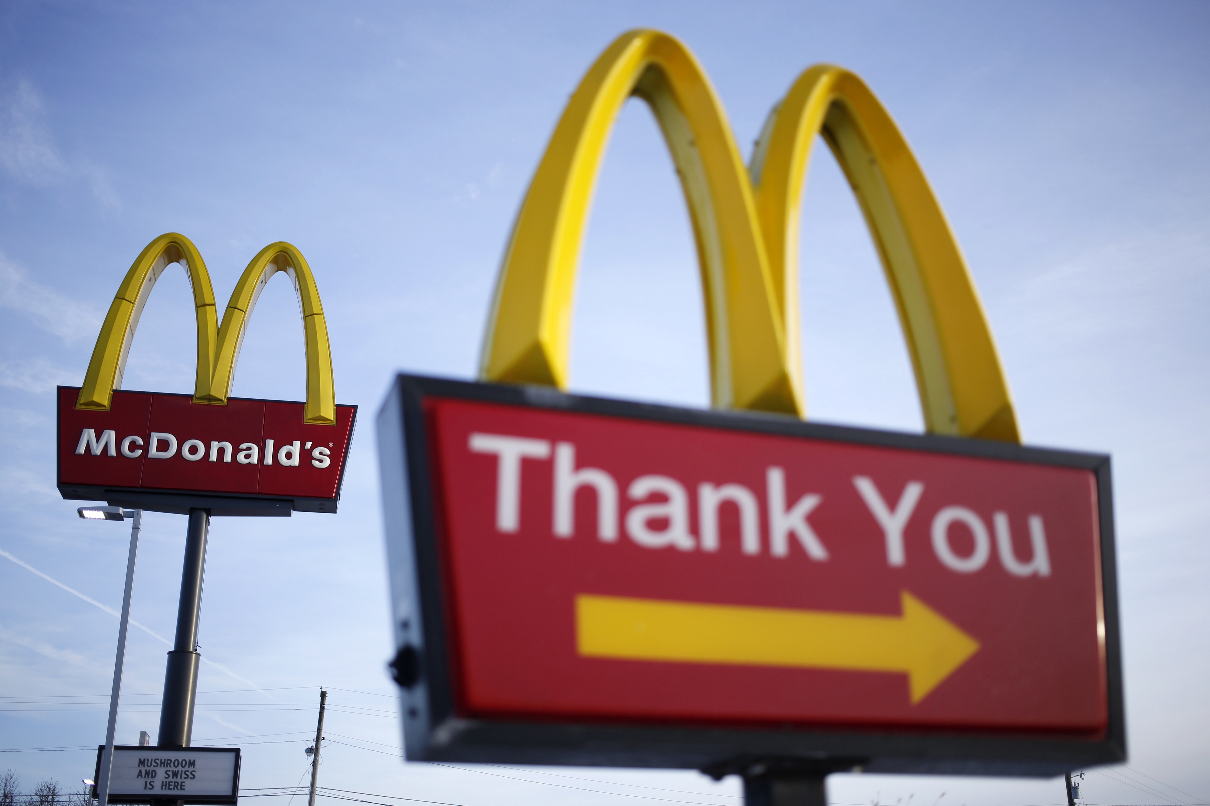McDonald's signs with "Thank You" and golden arches on display against a clear sky, implying customer appreciation