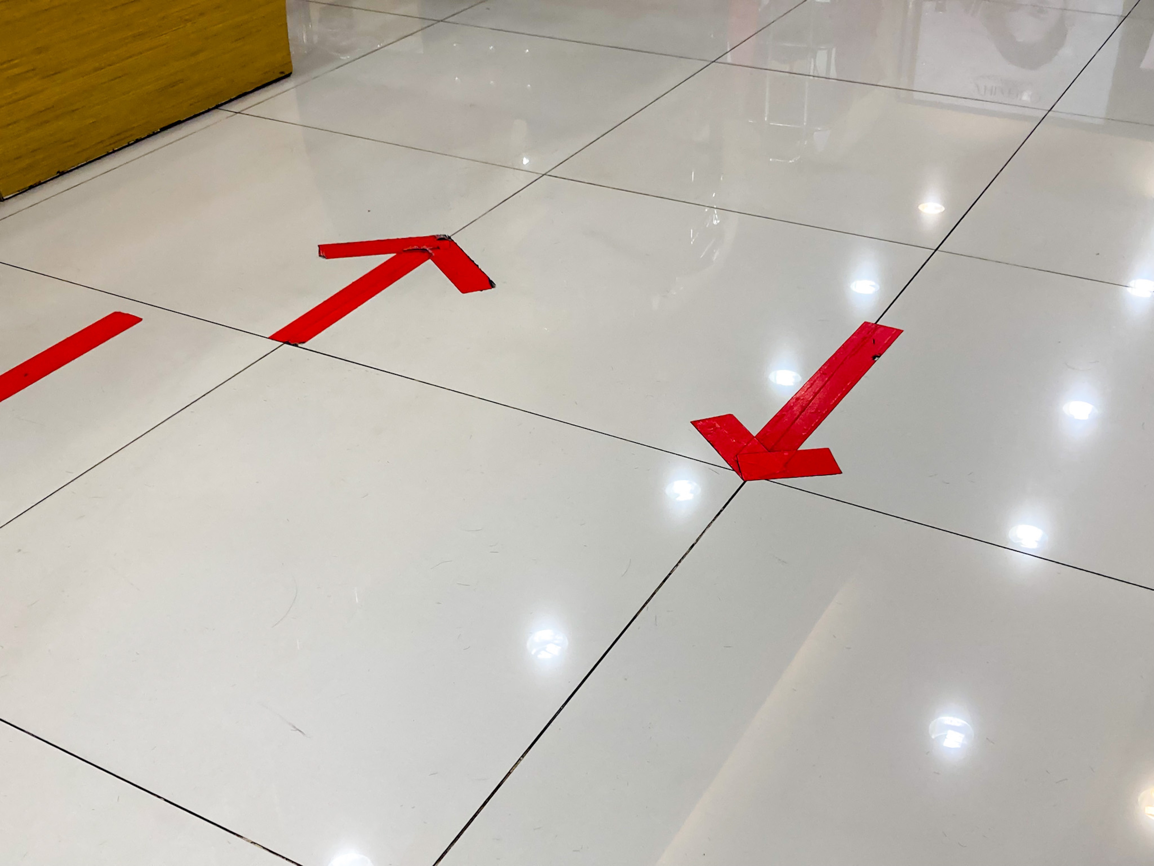 Floor with red directional arrows indicating traffic flow in a store or public space