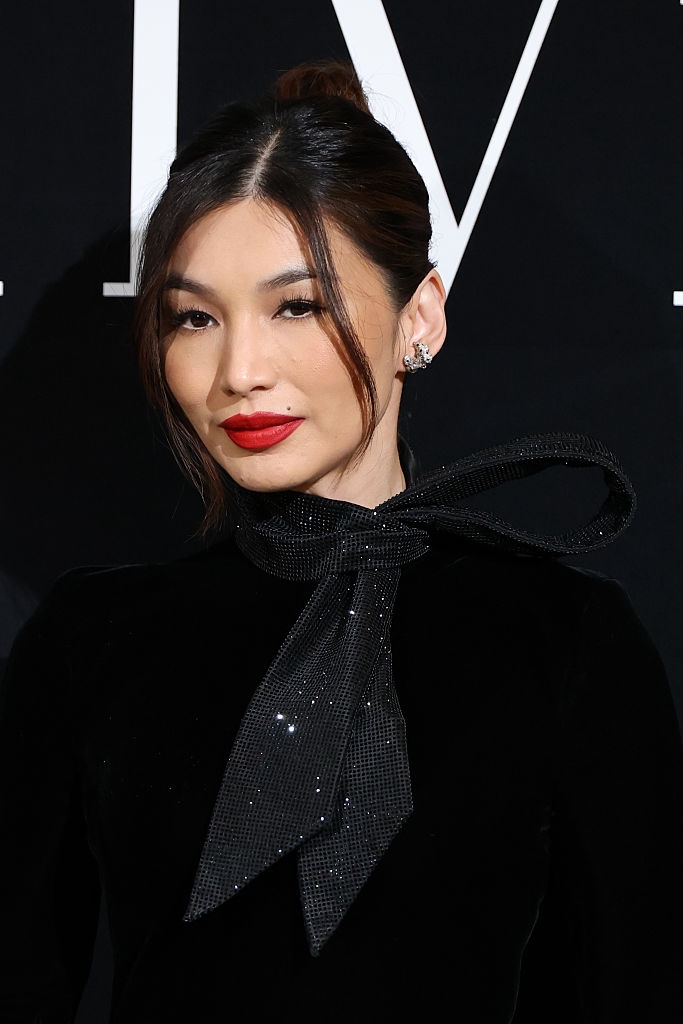 A pistillate connected a property lawsuit wears a chic, elegant outfit with a ample bow connected the neckline, styled with her hairsbreadth up and bold lipstick