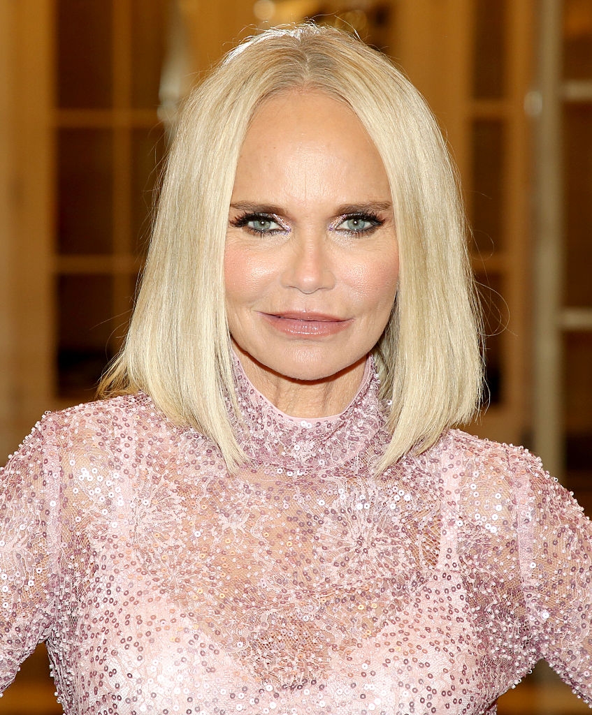 Person successful a high-collared, sequined formal with shoulder-length hair, posing connected the reddish carpet indoors