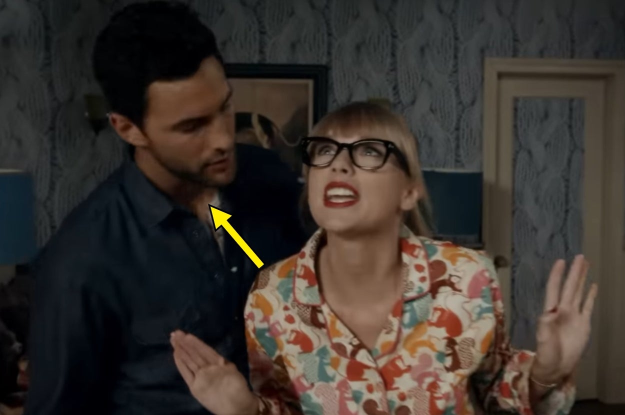 A person wearing glasses smiles enthusiastically next to another person in a room