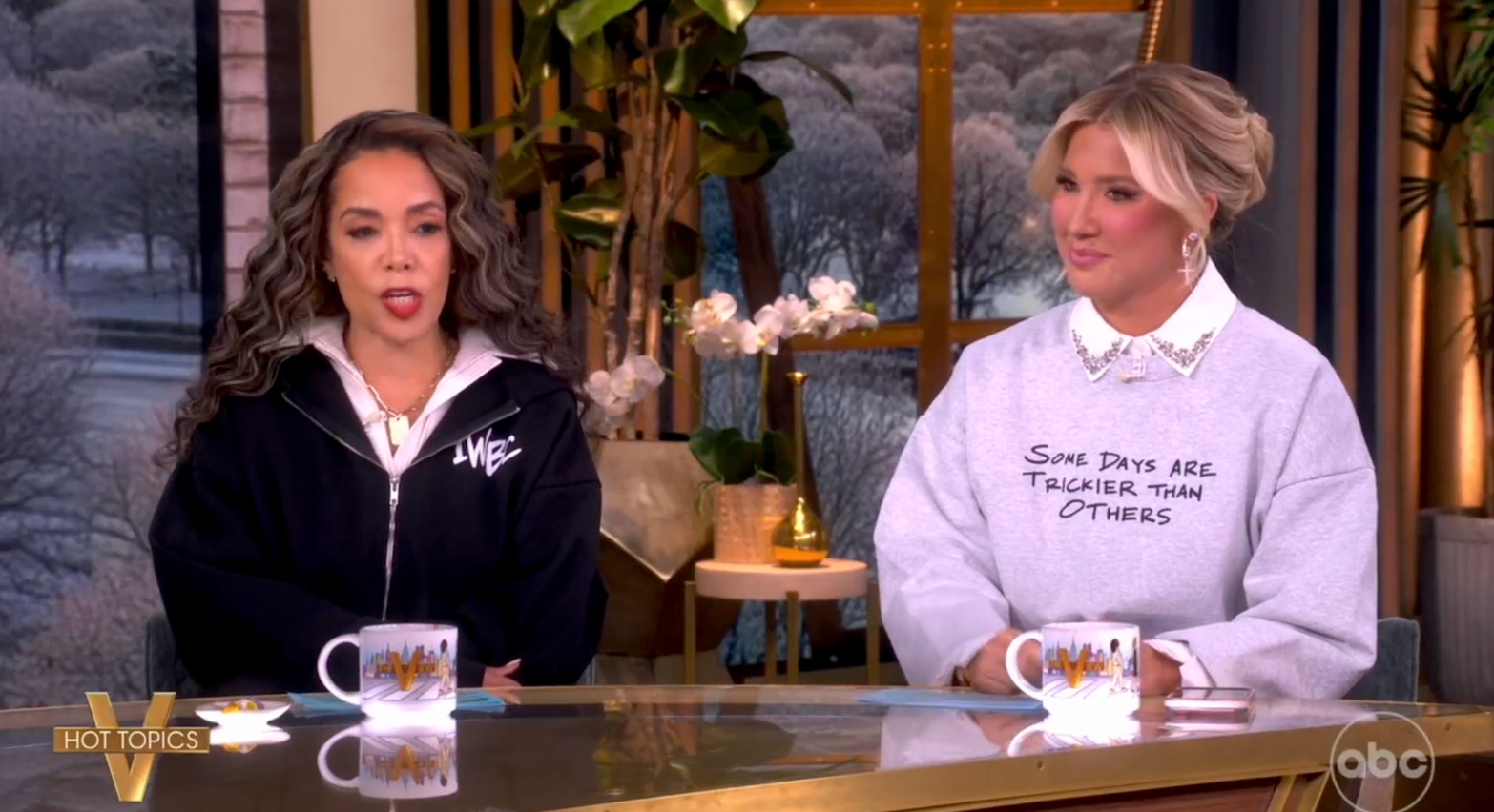 Two women beryllium   astatine  a speech   amusement   array  wearing casual sweatshirts, engaging successful  conversation