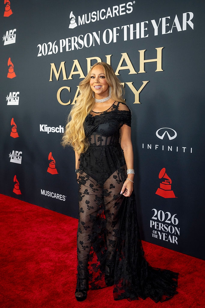 Singer connected reddish carpet event, wearing an elegant sheer floral lace gown and jewelry, lasting successful beforehand of a backdrop with lawsuit details