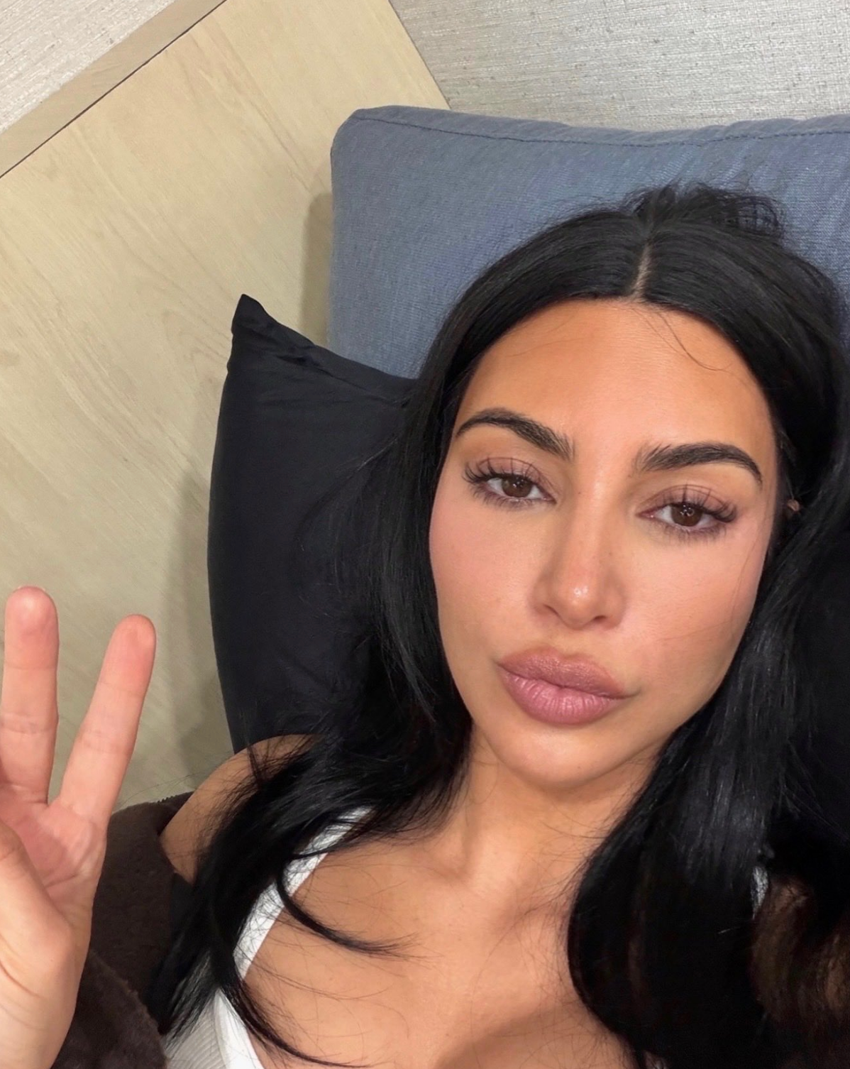 Kim making a bid    sign, looking astatine  the camera