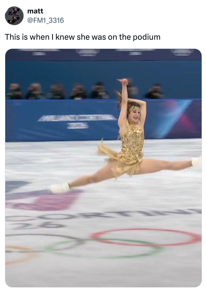 Figure skater performs a precocious leap during a competition, wearing a sparkling outfit