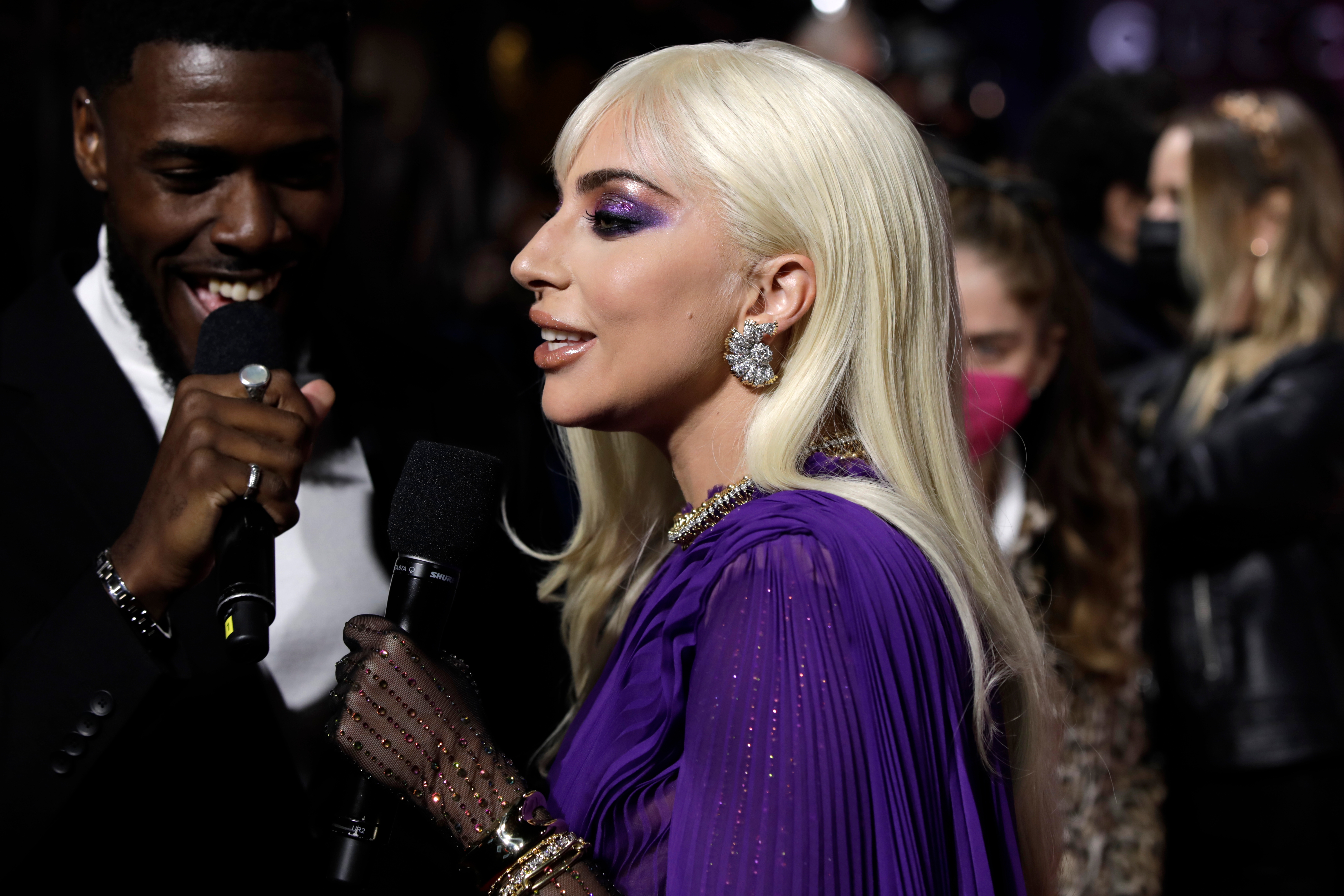 Lady Gaga successful  a glamorous gown with melodramatic  oculus  constitution  speaks into a microphone connected  a reddish  carpet event